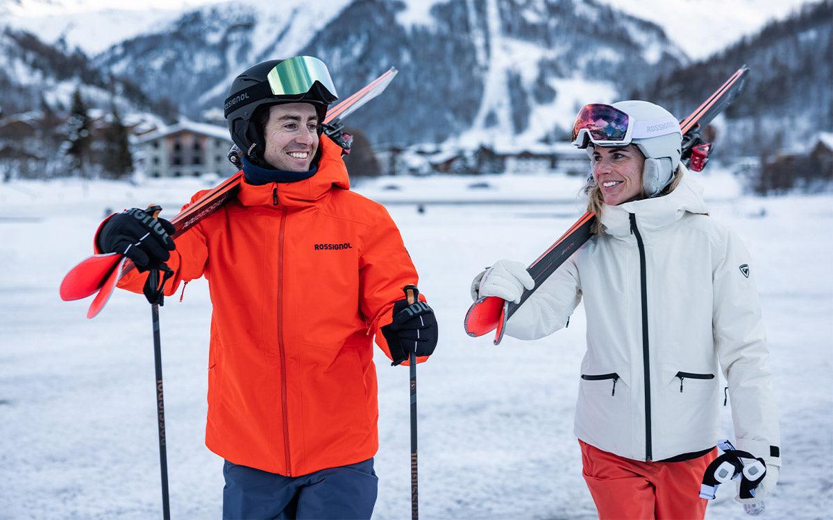 Una coppia in montagna con abbigliamento e attrezzatura da sci discesa Rossignol