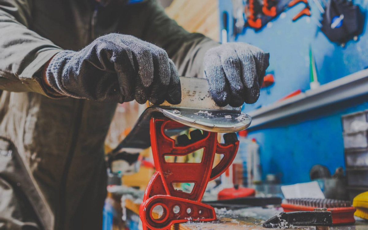 Tecnico rimuove la vecchia sciolina da uno sci.