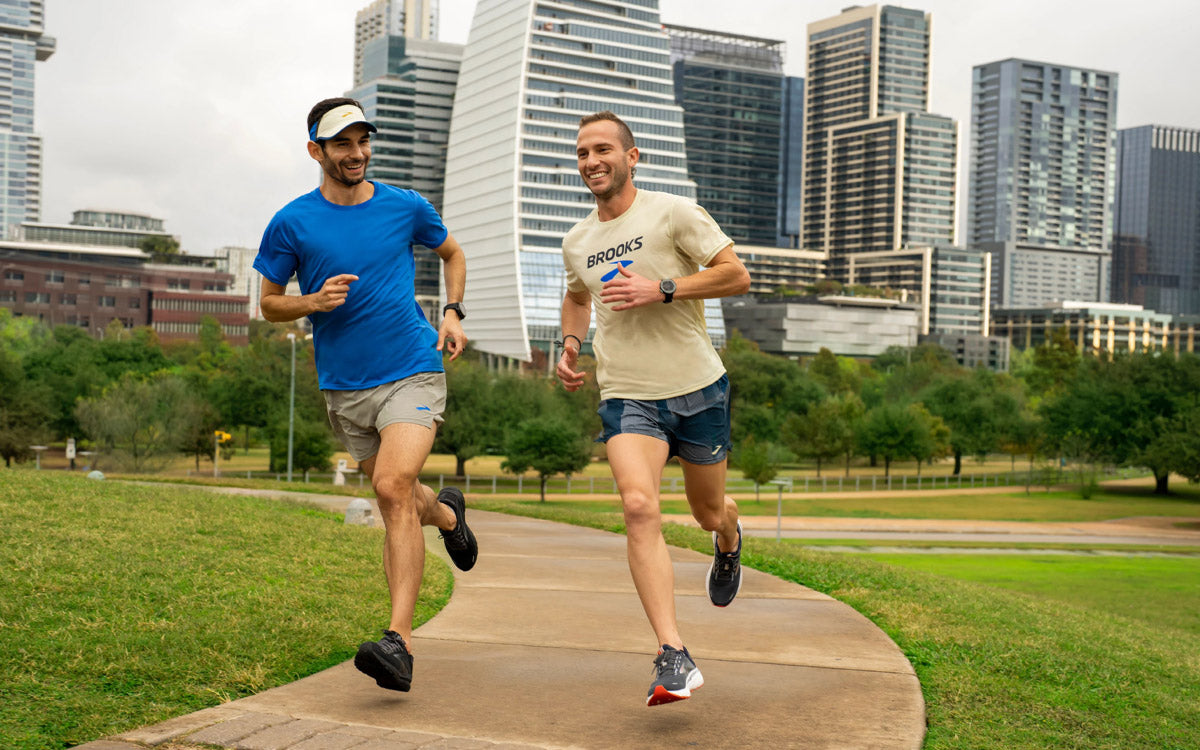 Due ragazzi corrono insieme in un parco cittadino