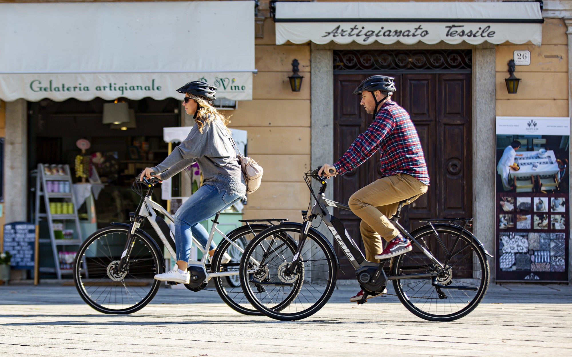 2 ragazzi pedalano in città su e-bike Atala
