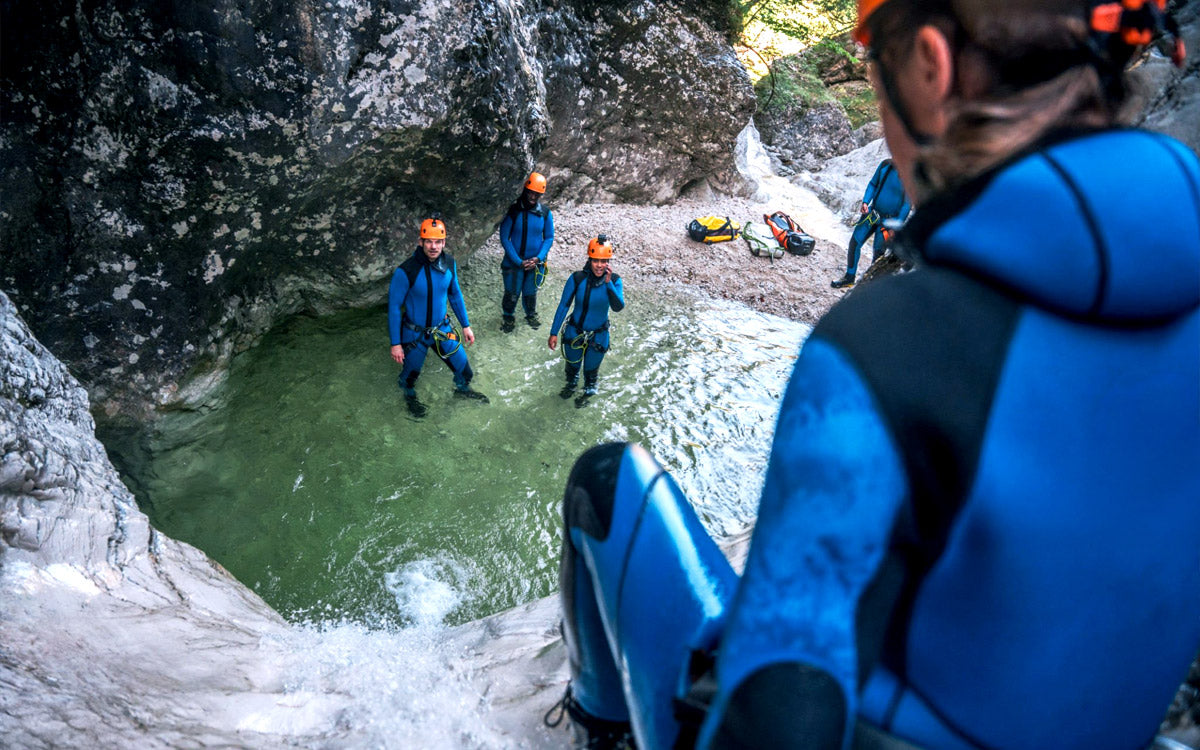 Una ragazza sta per affrontare uno scivolo durante un'attività di canyoning