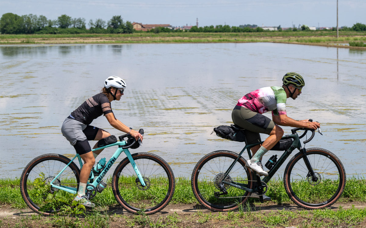 2 ragazzi pedalano su uno sterrato con bici gravel Bianchi Arcadex