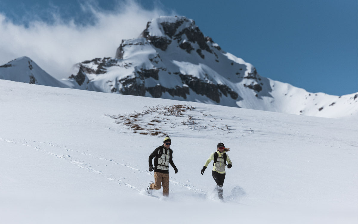 2 ragazzi con abbigliamento Salomon mentre camminano nella neve in montagna