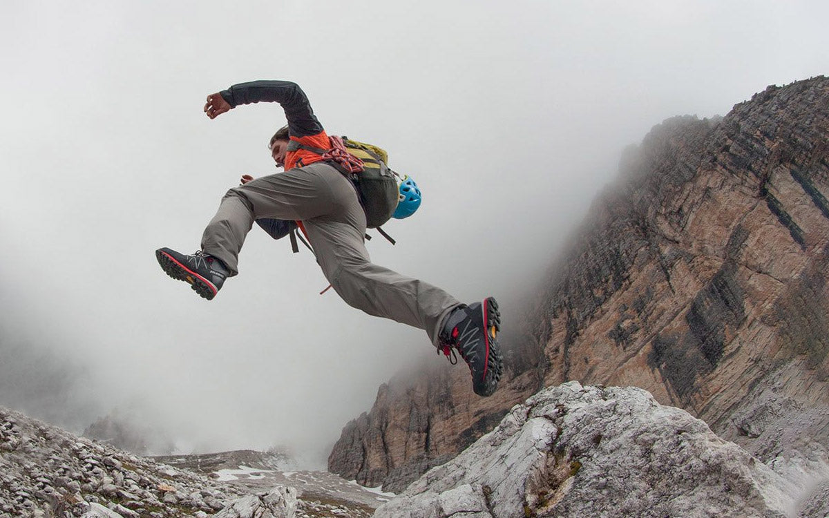 Ragazzo che salta sulle rocce indossando una paio di scarponi Dolomite Crodarossa Pro GTX