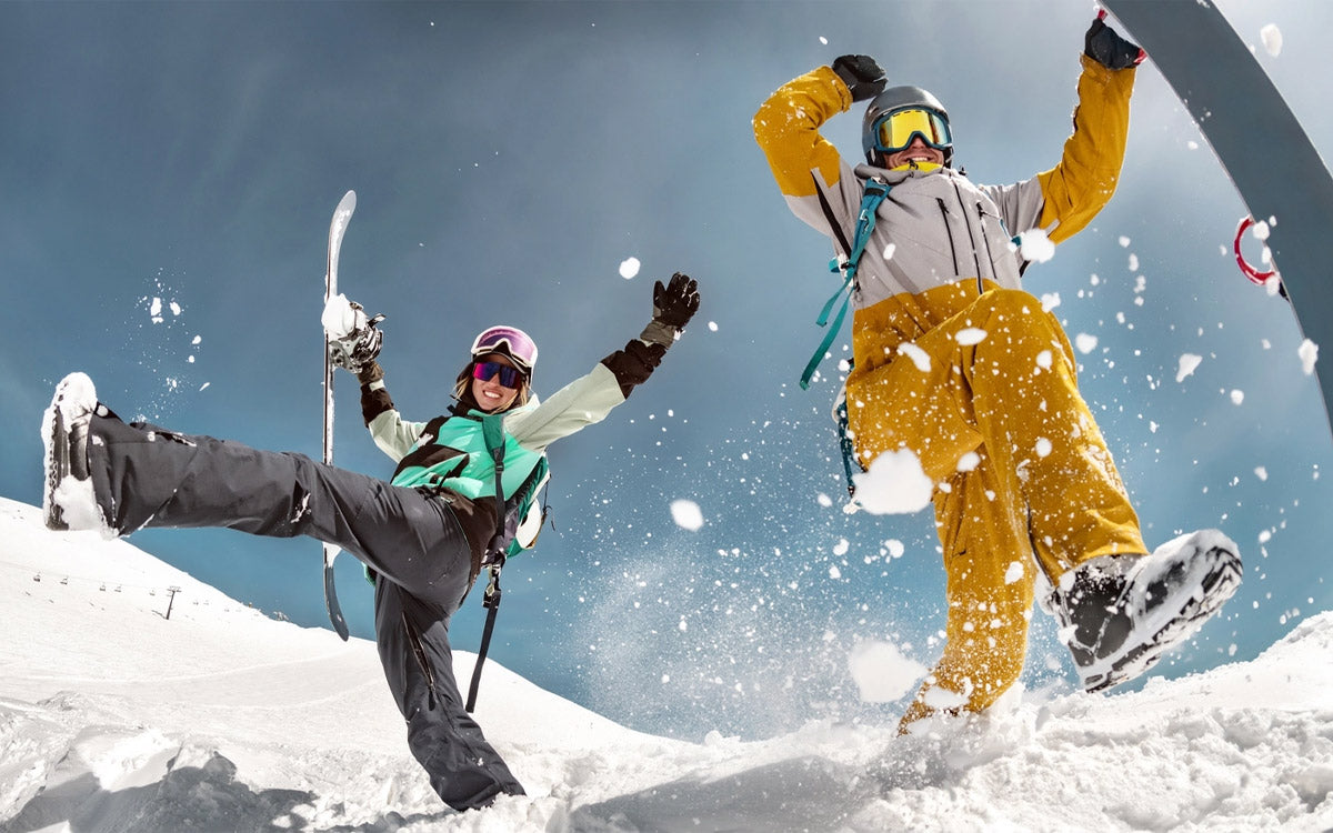 Una coppia di ragazzi si diverte sulla neve con gli snowboard